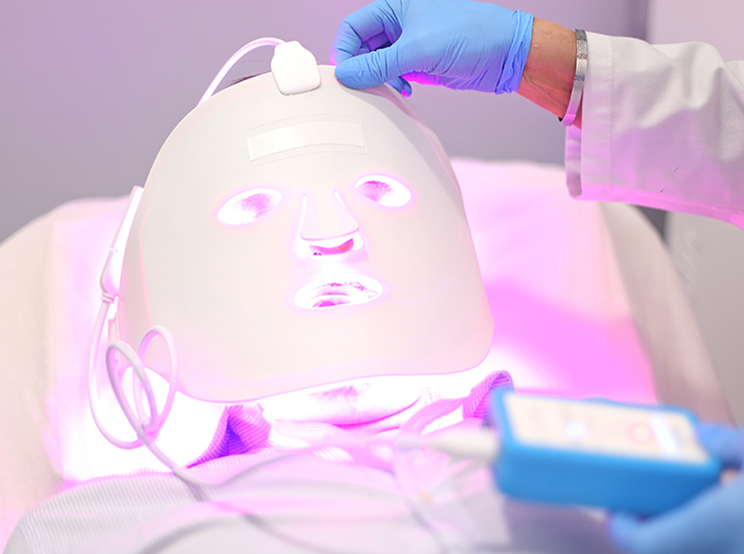 Zdjęcie przedstawia zabieg terapii światłem LED, który wykorzystuje różne długości fal świetlnych w celu poprawy kondycji skóry, redukcji zmarszczek i stanu zapalnego.